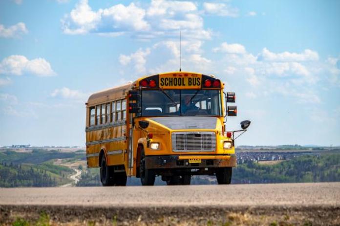School bus with blue sky and clouds.