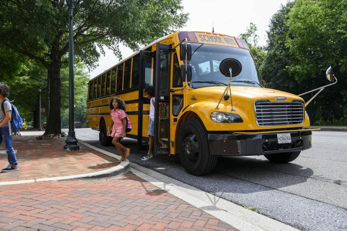 Students deboarding an electric school bus