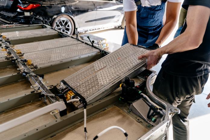 Workers load EV battery packs.