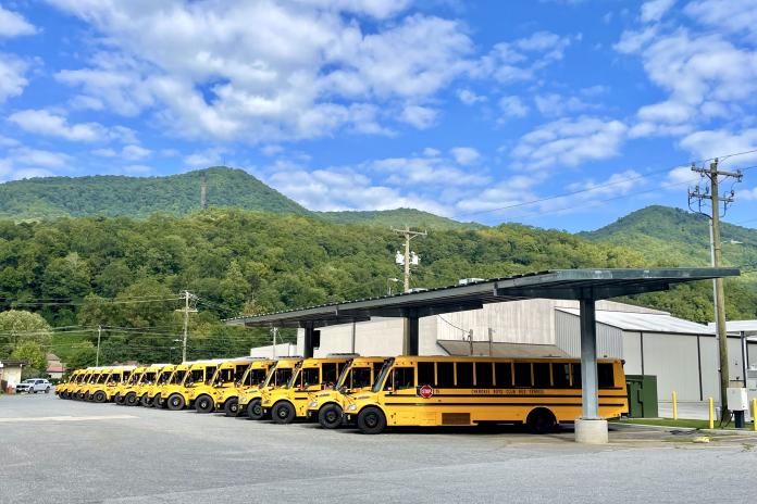 ESBs under solar canopy in front of mountains at Cherokee - WRI's Electric School Bus Initiative