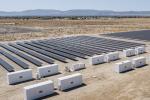 A field of solar panels with onsite battery storage.