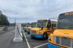 Electric school buses charging in a school bus depot.  