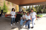 People sitting at picnic tables under a pavilion.