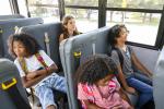 Four students sit on an electric school bus. 
