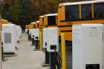 electric school buses charging in a lot