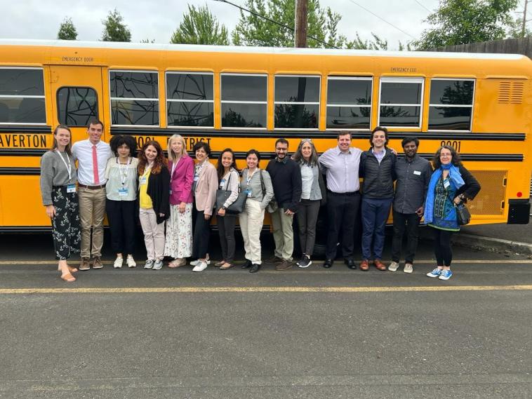 ESB Initiative staff members stand in front of an electric school bus.