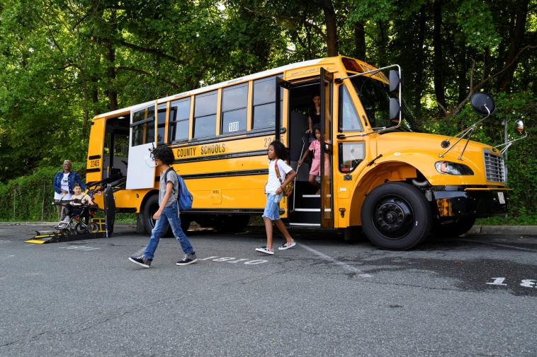 Students get off a school bus using both the stairs and the wheelchair lift.