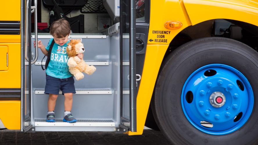 Young student deboarding a school bus