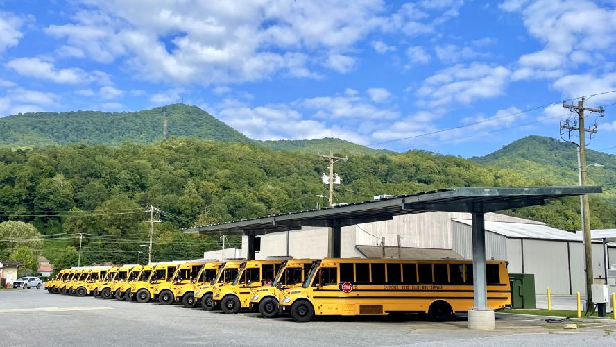 ESBs under solar canopy in front of mountains at Cherokee - WRI's Electric School Bus Initiative